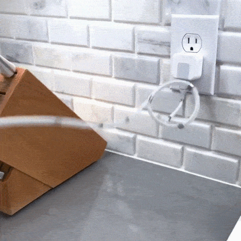 Magnetic charging cable coiled neatly at a wall outlet