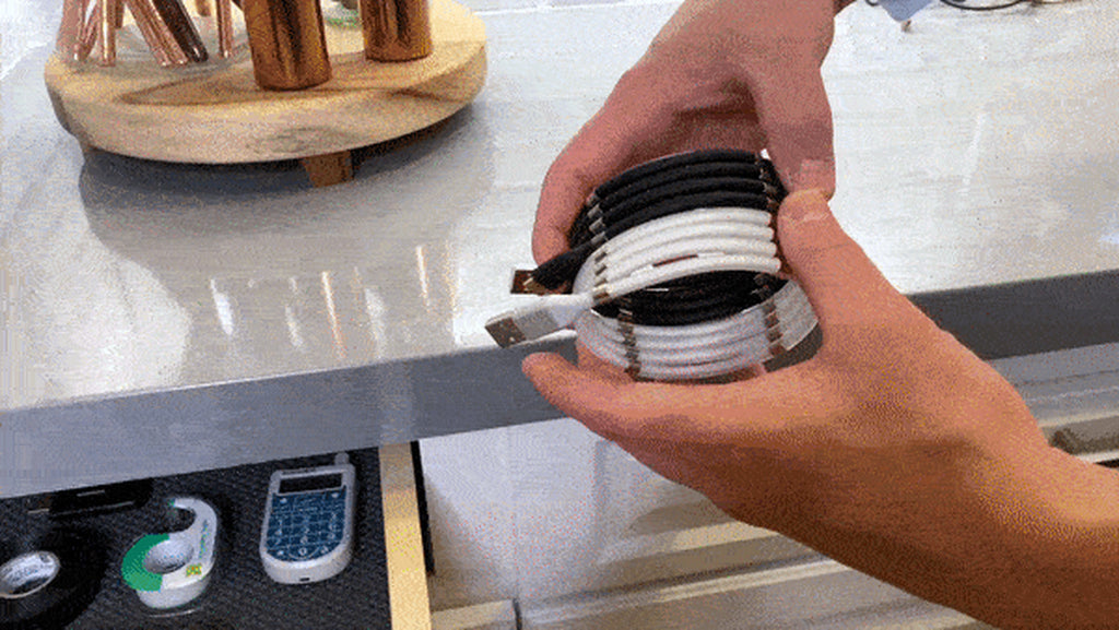 Magnetic charging cable wound into a compact coil held in a hand